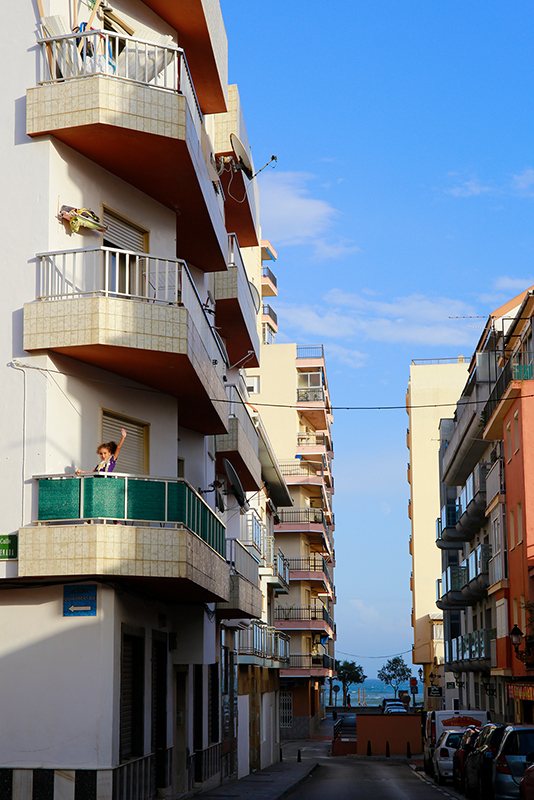a child waving from a balcony in Fuengirola, Spain